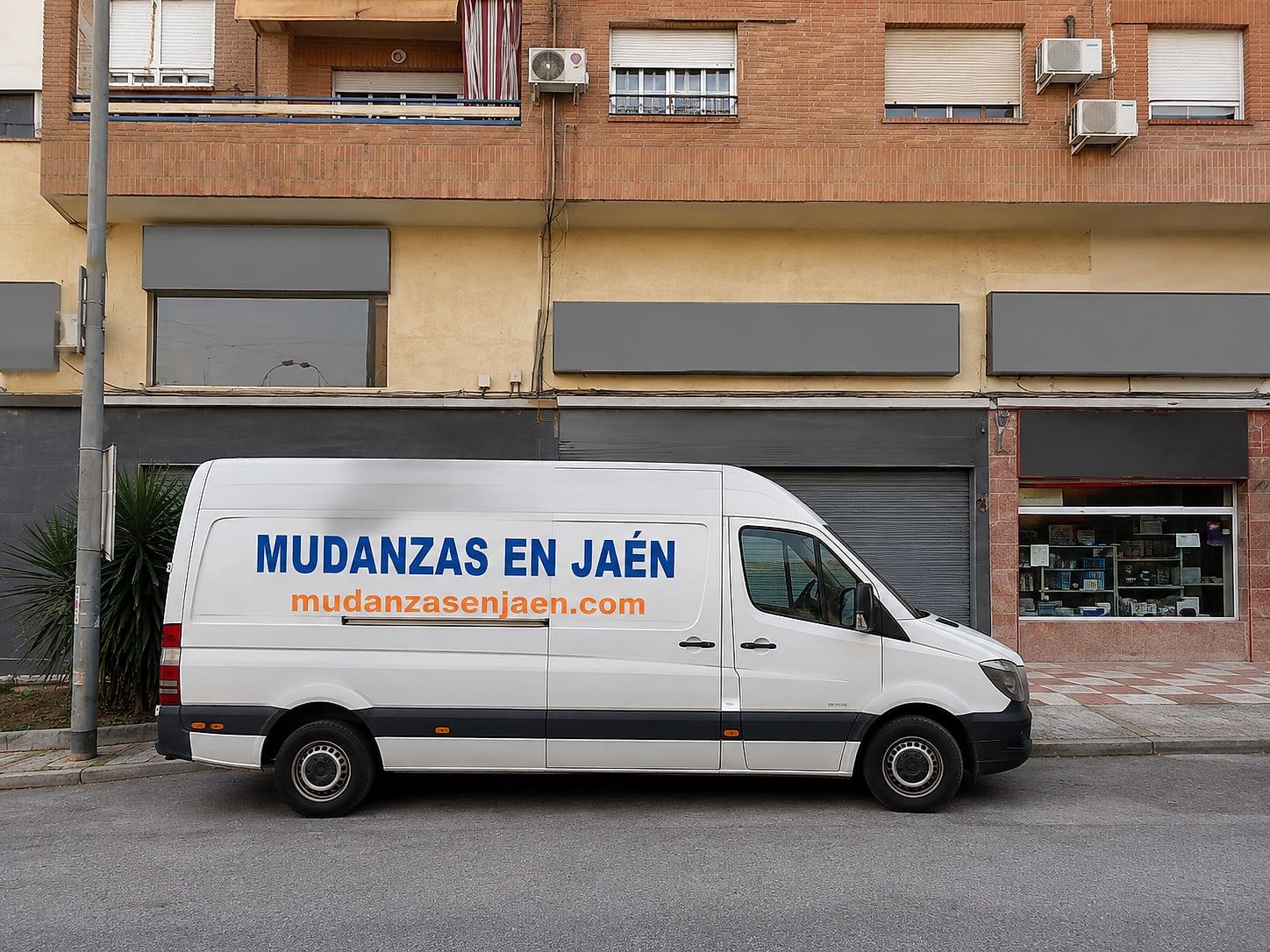 Portal de la base de Mudanzas en Jaén en la calle Europa, 72, con el furgón aparcado delante